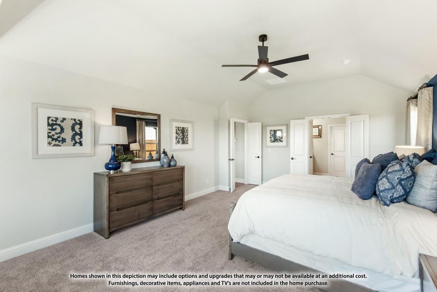 Bedroom with vaulted ceiling, ceiling fan, carpet flooring, and wood dresser with mirror Bedroom with vaulted ceiling, ceiling fan, carpet flooring, and wood dresser with mirror