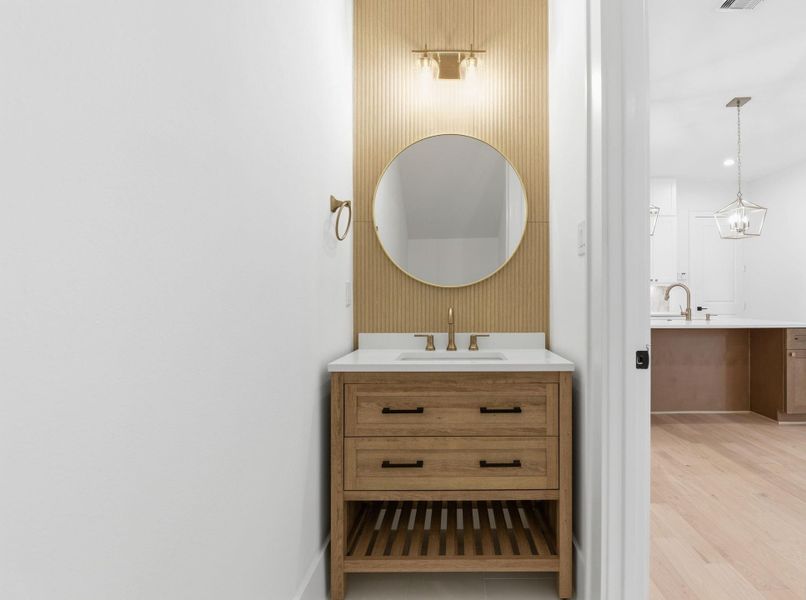 Stylish first-floor powder bathfeaturing designer finishes, customvanity, and decorative accent tile. (Photo of a previous build, similar finishes.)