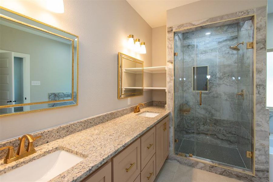 Bathroom with vanity, tile patterned flooring, and a shower with door