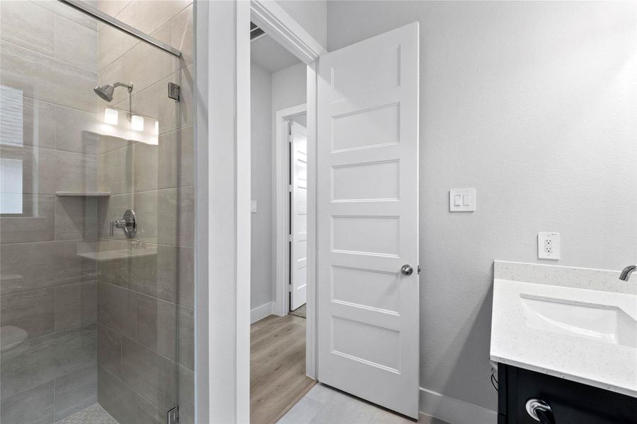 Additional view of the walk-in shower with tile surround and glass frame.