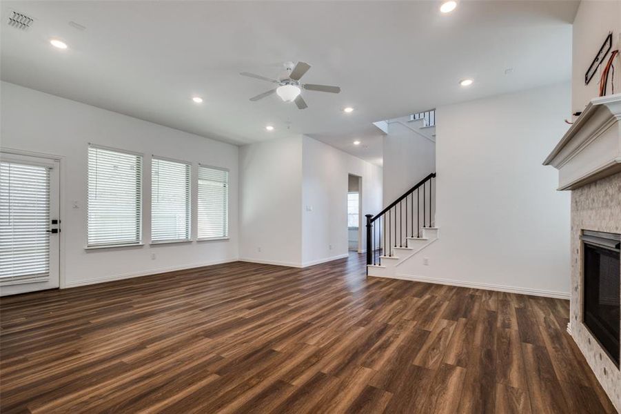 Unfurnished living room with ceiling fan, a fireplace, and dark hardwood / wood-style floors