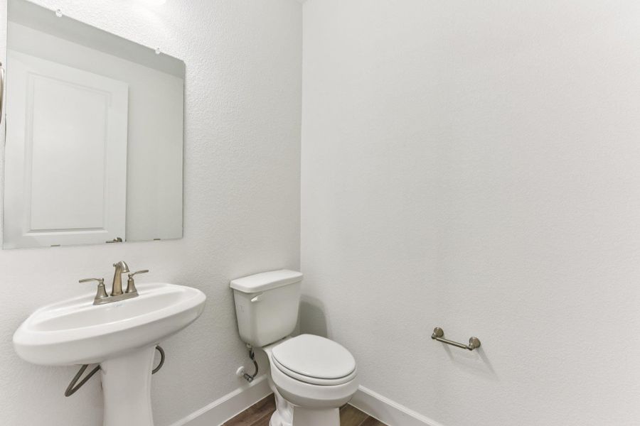 Half bath featuring a textured wall and wood finished floors Half bath featuring a textured wall and wood finished floors