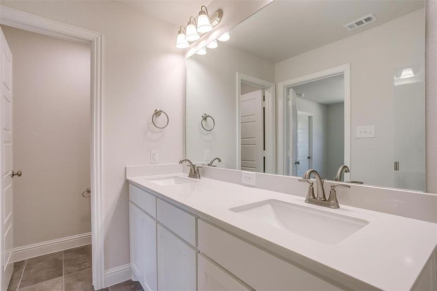Bathroom with double vanity and light tile patterned floors Bathroom with double vanity and light tile patterned floors