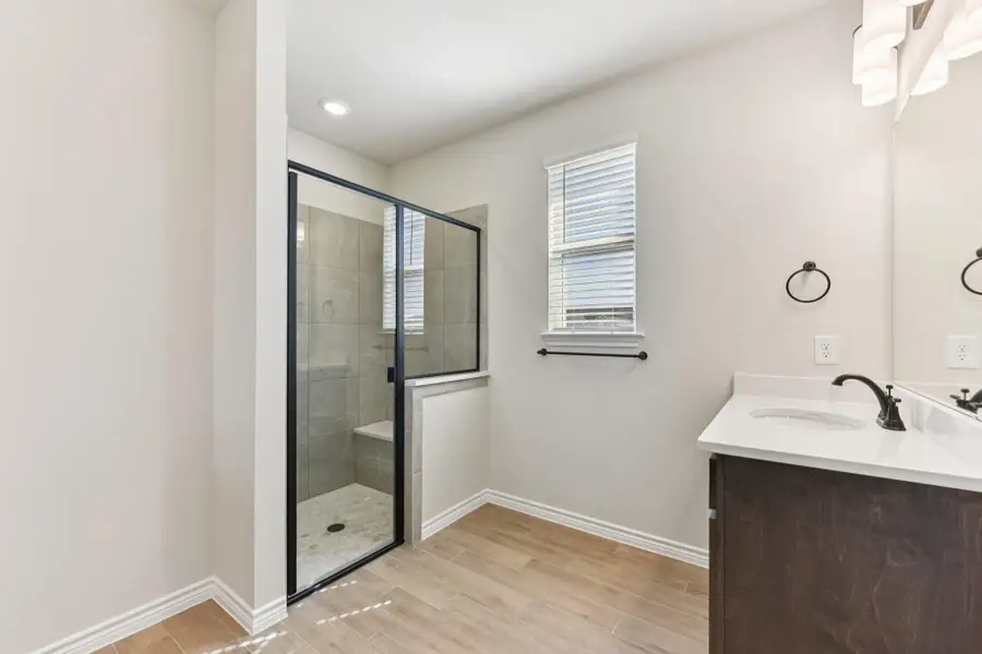 Bathroom with wood tiled floors, vanity, and a shower stall