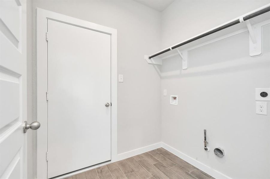 A perfect blend of functionality and comfort. Laundry room, thoughtfully equipped with shelving for effortless organization. Both gas and electric connections available. Sample photo of completed home with similar floor plan. As-built interior colors and selections may vary.