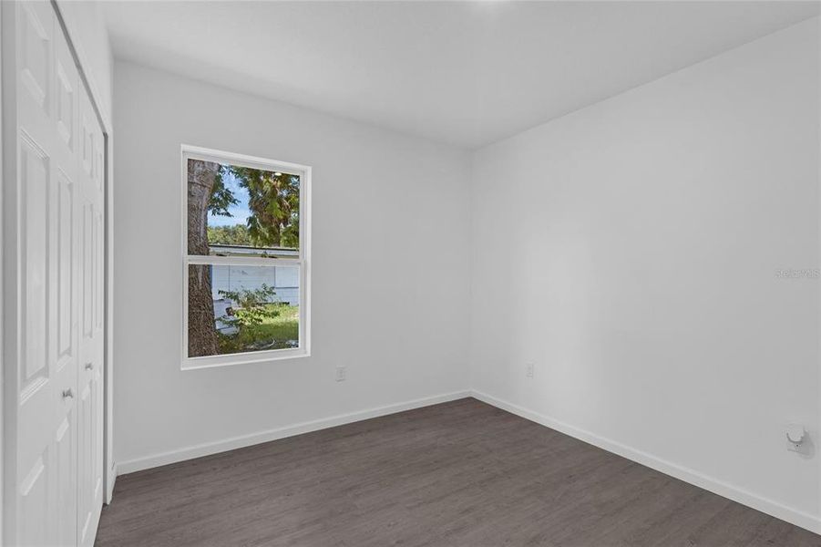 Bedroom three with luxury vinyl flooring and large closet