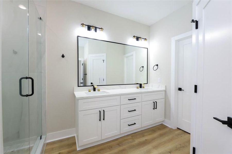 Primary Bathroom features a glass encased walk-in shower and separate soaking tub w/ dual vanities & walk-in closet.