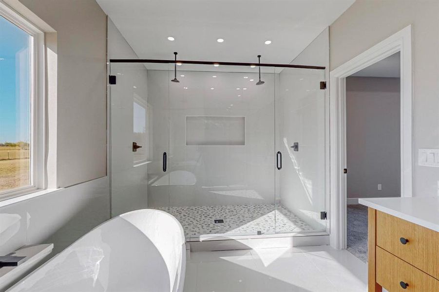 Bathroom featuring vanity and separate shower and tub