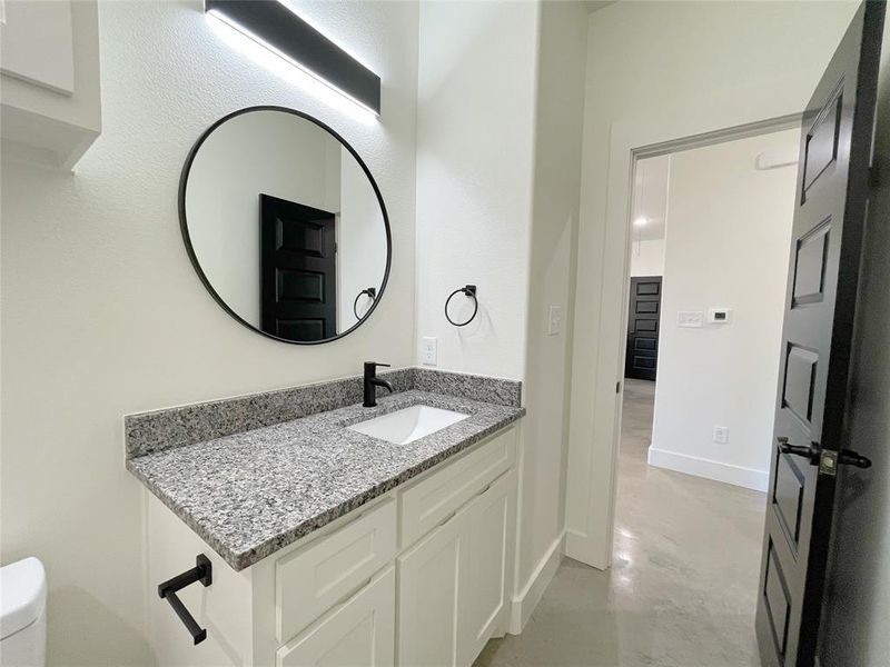 Bathroom featuring vanity, concrete floors, and toilet