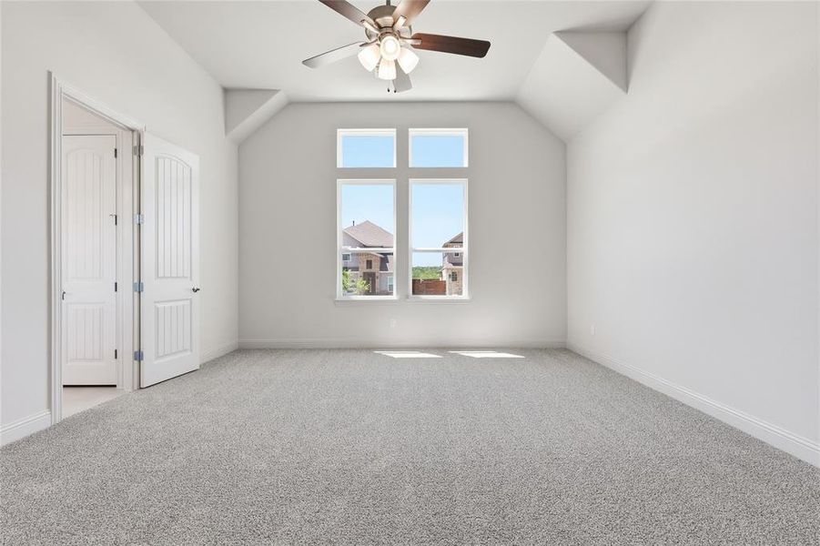 Bonus room with vaulted ceiling, carpet floors, and ceiling fan