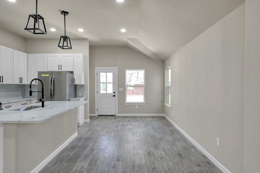 Dedicated breakfast area situated under a unique vaulted ceiling detail, featuring large windows that invite plenty of natural light.