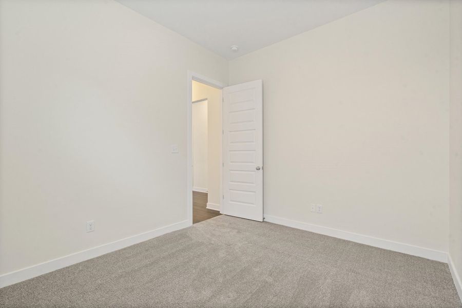 Light gray carpeting, white baseboards, and neutral wall tones define this interior space Light gray carpeting, white baseboards, and neutral wall tones define this interior space