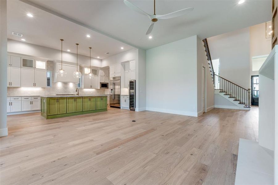 Kitchen with green cabinetry, glass insert cabinets, white cabinets, light wood-style flooring, and recessed lighting Kitchen with green cabinetry, glass insert cabinets, white cabinets, light wood-style flooring, and recessed lighting