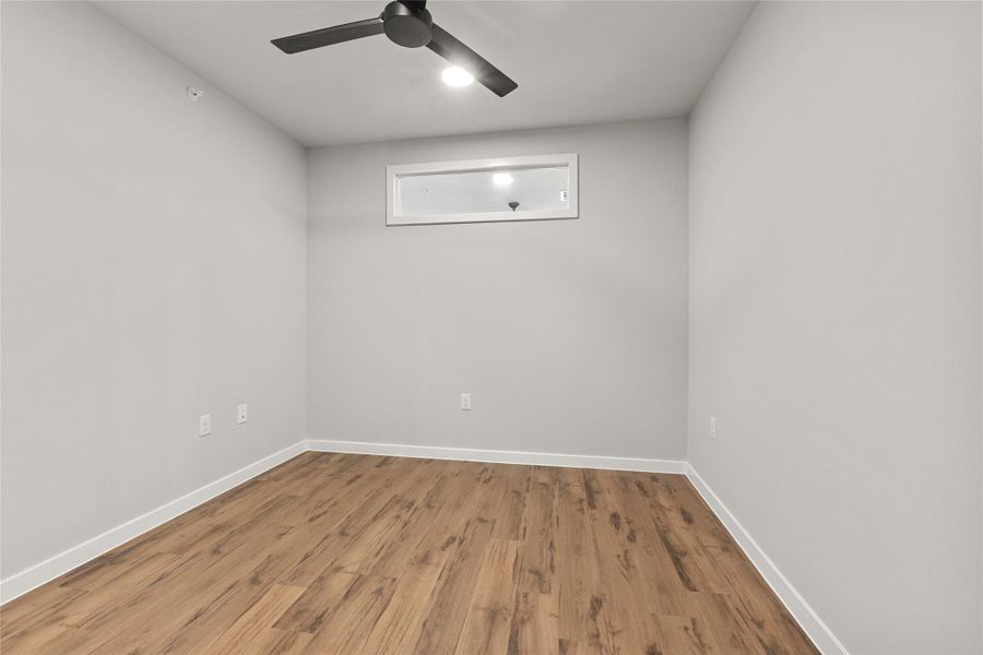 Empty room with ceiling fan and light wood-style floors