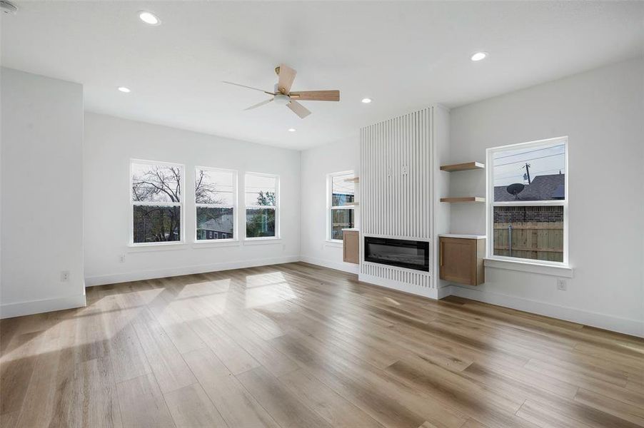 Unfurnished living room with ceiling fan and light hardwood / wood-style floors