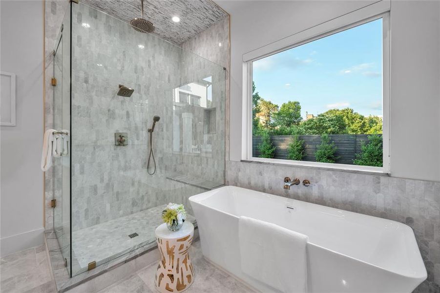Full bathroom featuring a freestanding bath, a shower stall, and tile walls Full bathroom featuring a freestanding bath, a shower stall, and tile walls