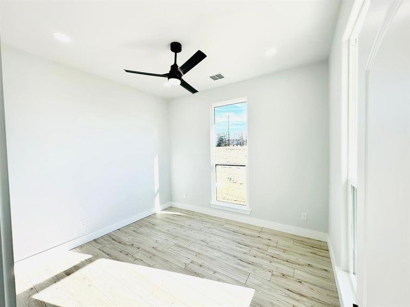 Spare room featuring ceiling fan and light hardwood / wood-style flooring