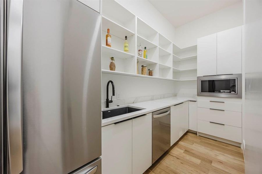 Kitchen with modern cabinets, appliances with stainless steel finishes, and white cabinetry Kitchen with modern cabinets, appliances with stainless steel finishes, and white cabinetry