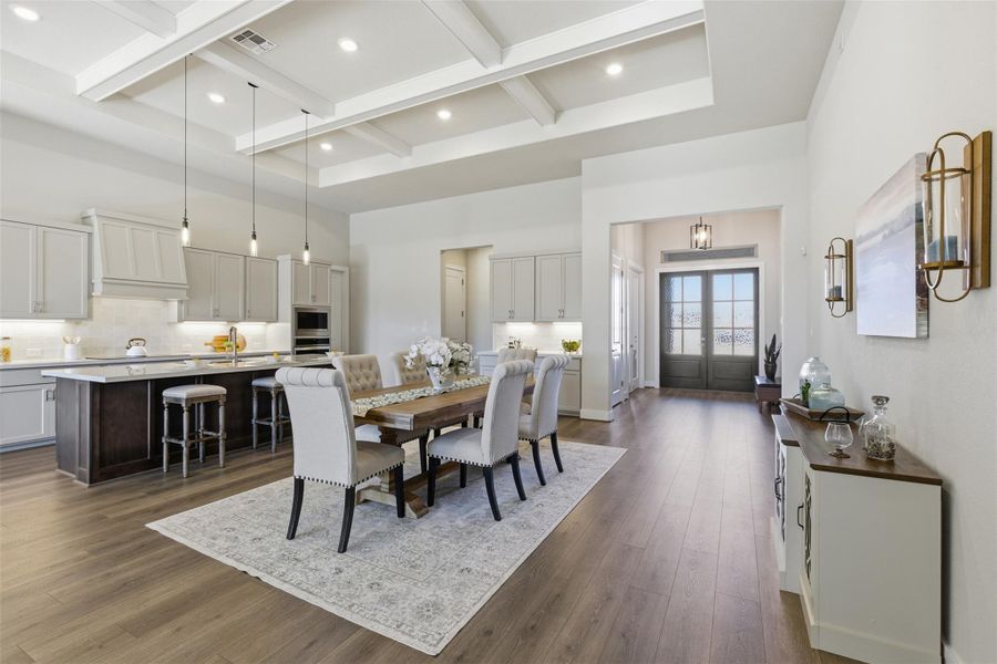 Dining space with coffered ceiling, dark wood-style flooring, and recessed lighting