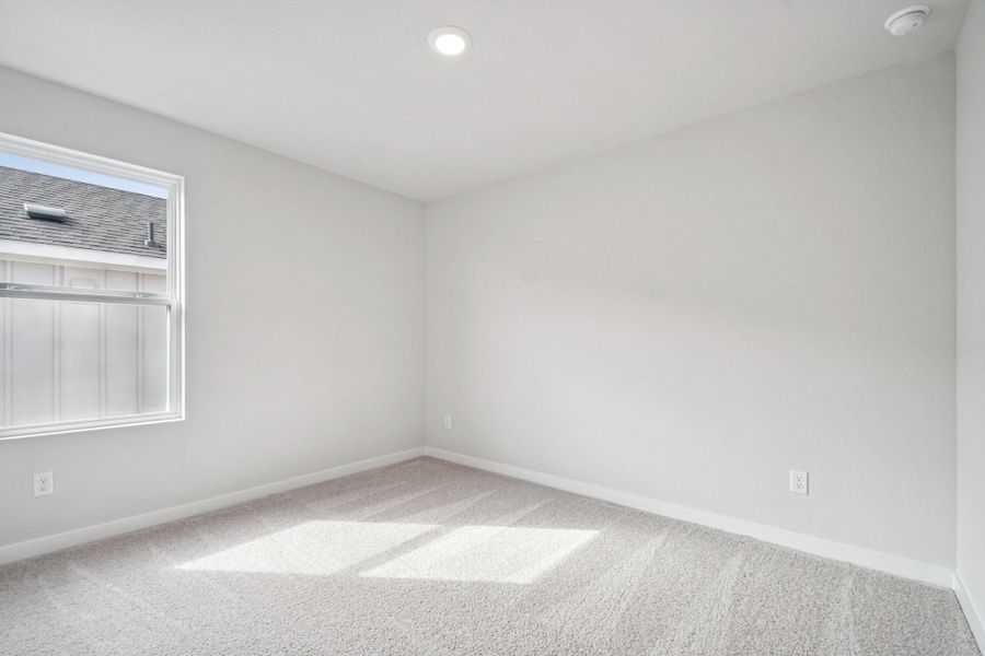 A room with a white wall and a window.