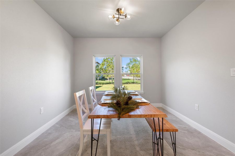 Dining area featuring baseboards and concrete floors