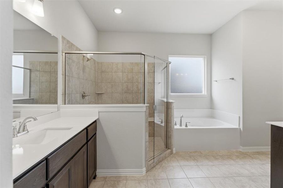 Bathroom featuring vanity, a garden tub, a stall shower, and light tile patterned flooring
