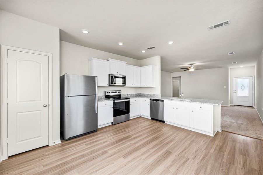 The kitchen is stocked with Whirlpool kitchen appliances and granite countertops.