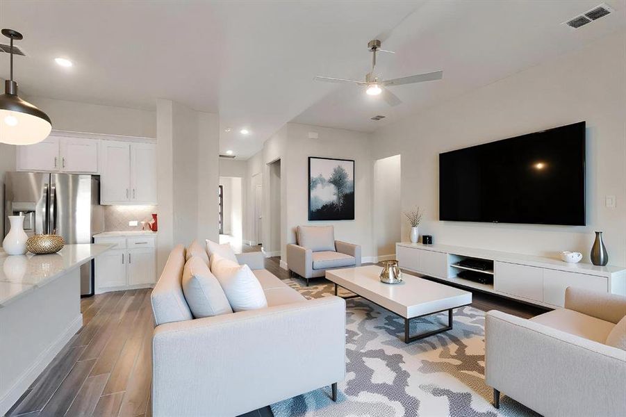 Living area with light wood finished floors, recessed lighting, and ceiling fan
