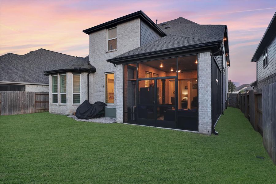 The backyard has a well maintained lawn and a spacious patio, perfect for outdoor gatherings, relaxing in the sun, or creating your own garden oasis.