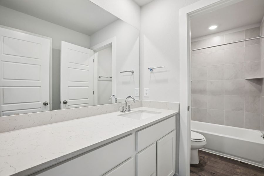 A bathroom with a tub sink and toilet.