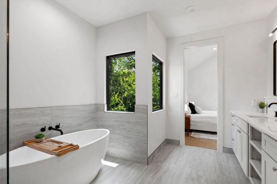 Luxurious soaking tub and tiled floors in a brightly illuminated bathroom. Luxurious soaking tub and tiled floors in a brightly illuminated bathroom.