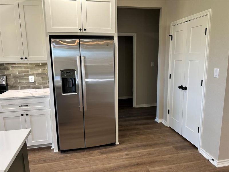 Kitchen featuring appliances with stainless steel finishes, white cabinetry, and light wood-style floors