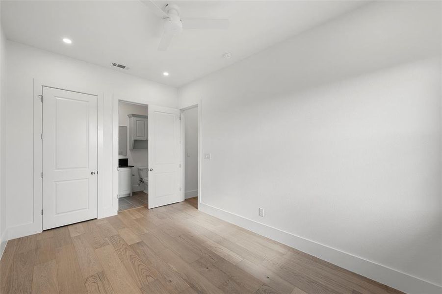 Unfurnished bedroom featuring light wood-type flooring, ensuite bathroom, recessed lighting, and ceiling fan Unfurnished bedroom featuring light wood-type flooring, ensuite bathroom, recessed lighting, and ceiling fan