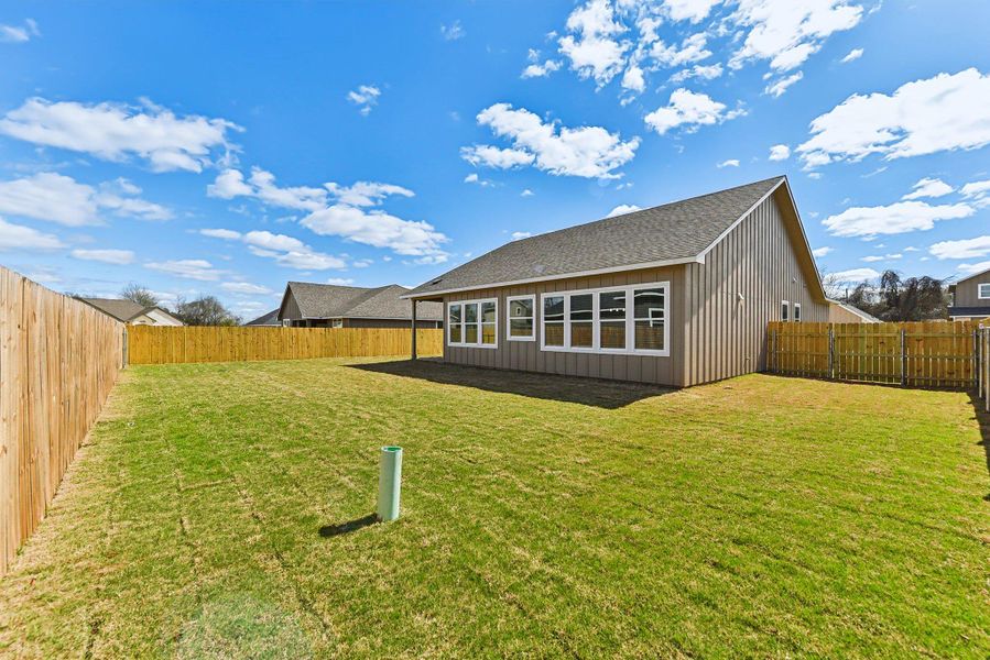 Rear view of property featuring a lawn, roof with shingles, and a fenced backyard Rear view of property featuring a lawn, roof with shingles, and a fenced backyard