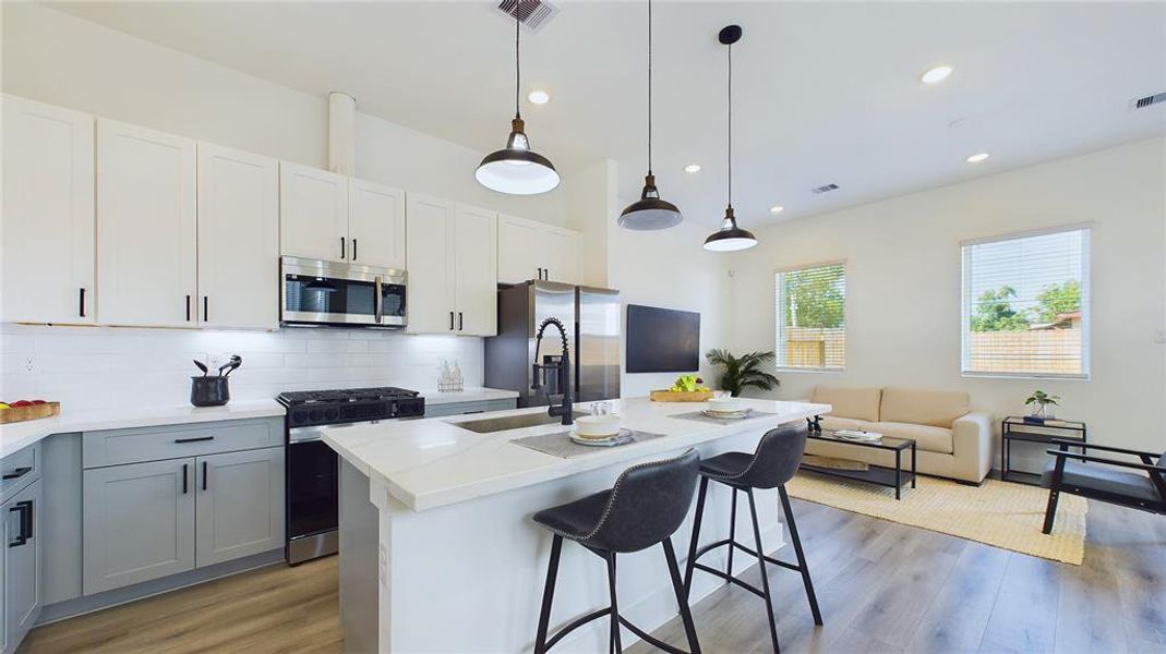 This attractive kitchen is full of beautiful details. Quartz Countertops, stainless sink, stainless steel appliances, recessed lighting, undercabinet lighting, Walk-in-Pantry, elegant cabinetry with soft close drawers and doors