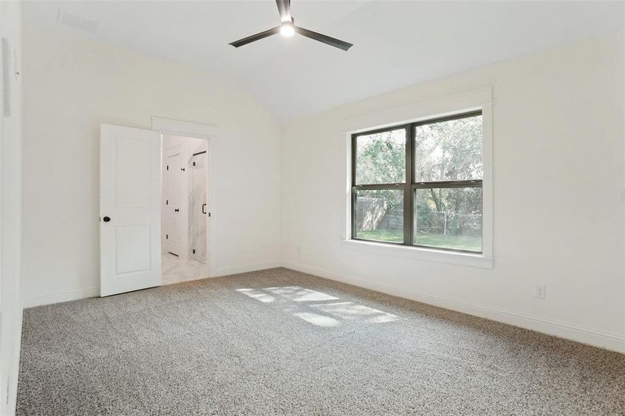 Unfurnished bedroom with vaulted ceiling, light carpet, and a ceiling fan