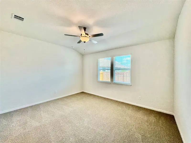 Spare room featuring carpet flooring, a textured ceiling, lofted ceiling, and ceiling fan