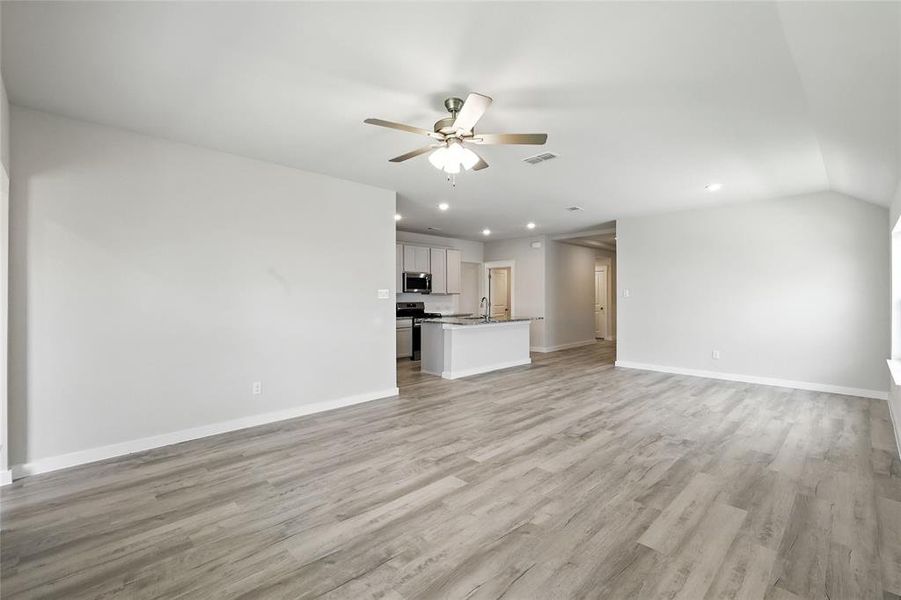 Unfurnished living room featuring a ceiling fan, recessed lighting, and light wood-style flooring