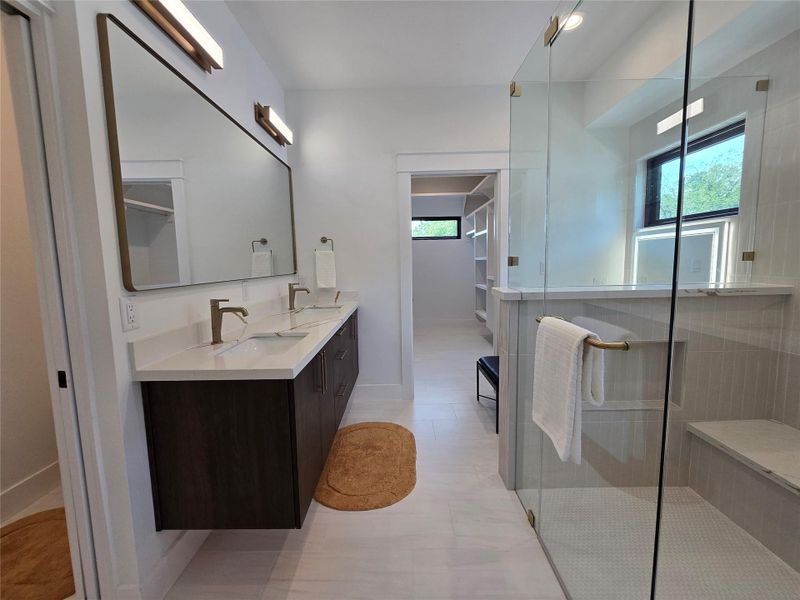 Bathroom featuring a stall shower, a sink, double vanity, and a healthy amount of sunlight Bathroom featuring a stall shower, a sink, double vanity, and a healthy amount of sunlight