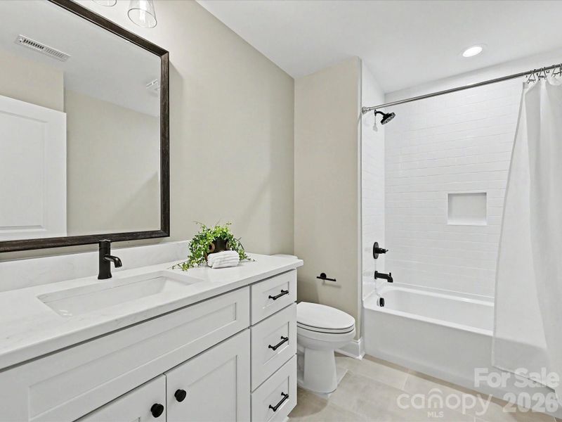 Stylish second full bath on upper level features modern finishes, a sleek vanity, and a tiled tub/shower combination.