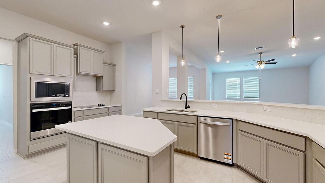 Kitchen featuring gray cabinetry, stainless steel appliances, a kitchen island, and ceiling fan Kitchen featuring gray cabinetry, stainless steel appliances, a kitchen island, and ceiling fan