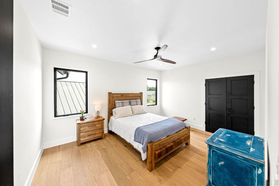 Gleaming hardwood floors and crisp white walls define this restful bedroom retreat.