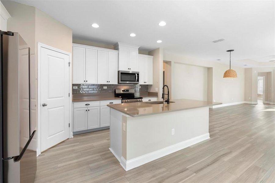 Large pantry , quartz countertops, recessed hd lighting, beautiful backsplash, whirlpool appliances, wood cabinets along with soft close drawers and metal hardware. plenty of outlets for all your cooking needs.