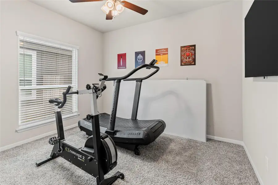 An airy home gym, well-lit by a large window, provides a dedicated space for fitness. An airy home gym, well-lit by a large window, provides a dedicated space for fitness.