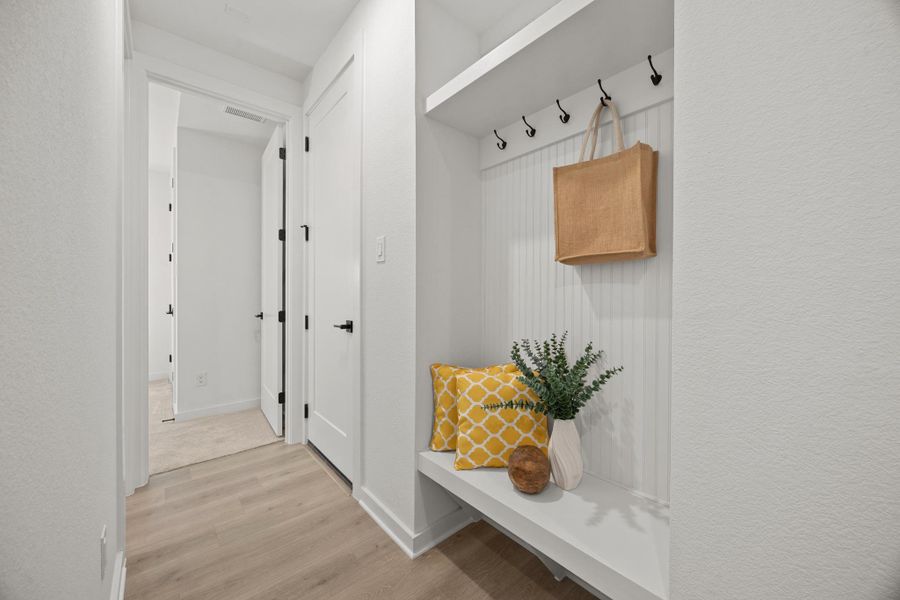 Mudroom with light wood-style floors and a textured wall