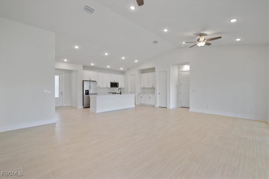 Unfurnished living room with recessed lighting, ceiling fan, lofted ceiling, and wood finish floors