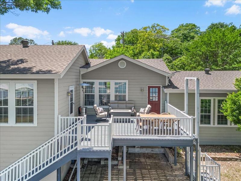 Back of property featuring roof with shingles, an outdoor living space, and a deck