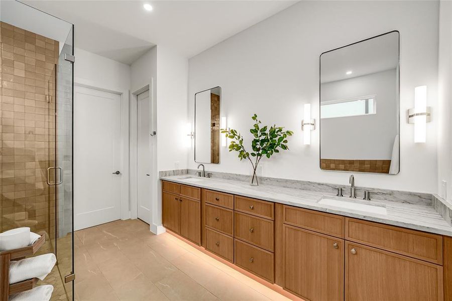 Contemporary bathroom featuring a long wood-finish vanity with dual undermount sinks, stone countertops, and rectangular mirrors