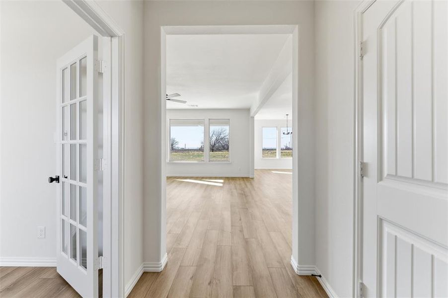 Corridor with light wood-style flooring and baseboards