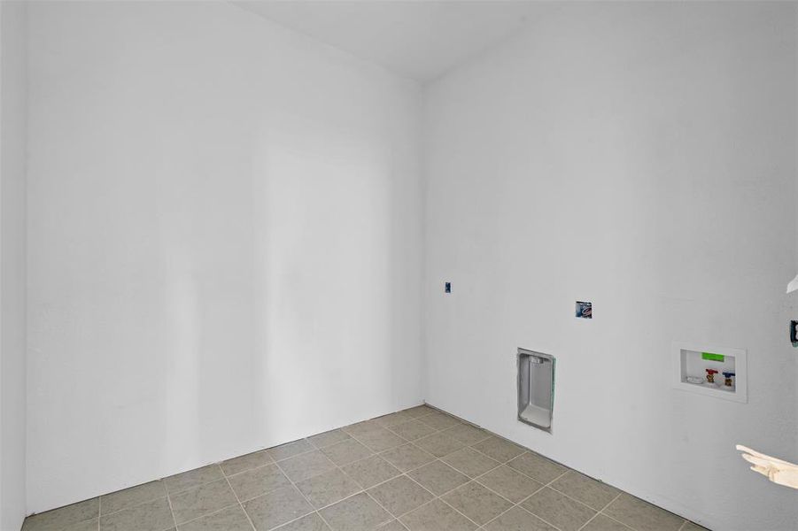 Laundry area featuring washer hookup and light tile patterned floors Laundry area featuring washer hookup and light tile patterned floors